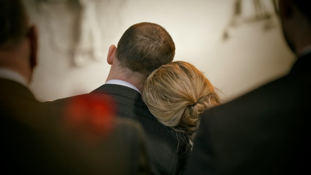 Koppel leunt tegen elkaar aan tijdens een emotioneel afscheid