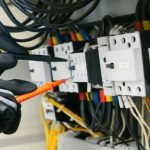 Elektricien controleert bedrading in groepenkast bij uitbreiding met extra groepen voor veilige stroomverdeling