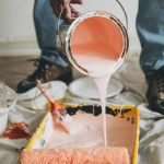 Verf wordt in een bak gegoten om muren te schilderen als onderdeel van periodiek onderhoud.